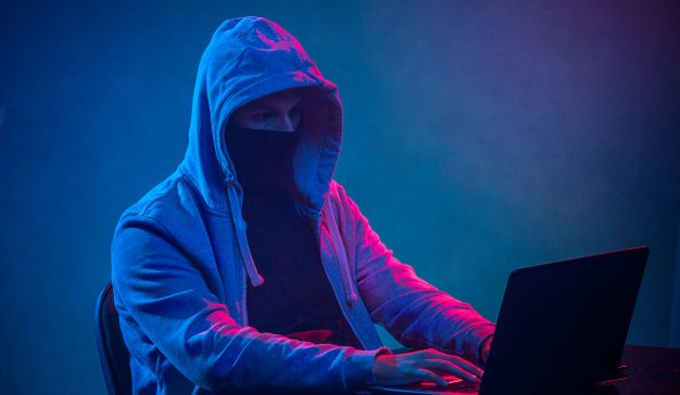 hooded-computer-hacker-stealing-information-with-laptop_155003-10571